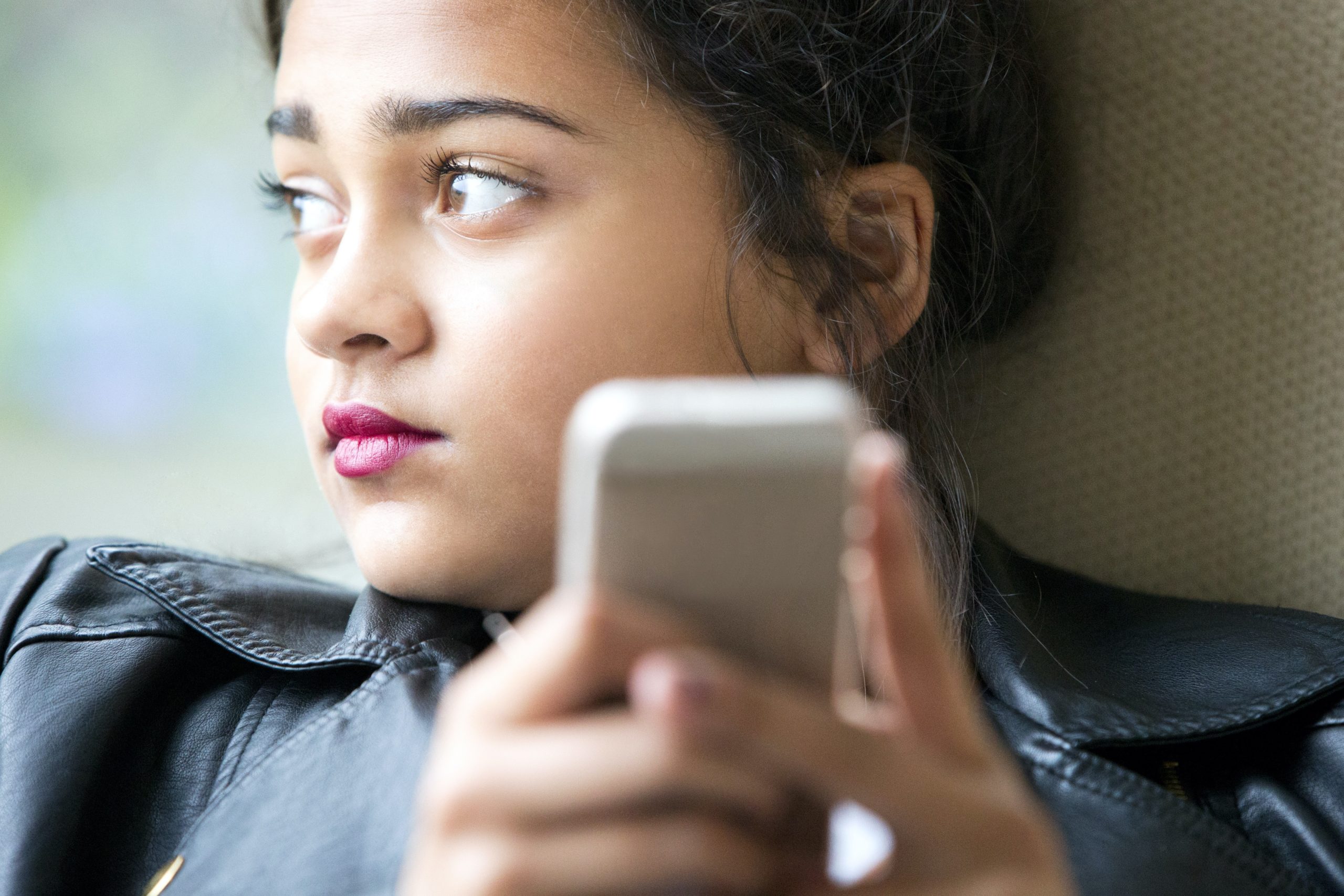 Young teenager looking away from phone. Teen anxiety can feel like the end of the world. Let's help you manage your teens anxiety.