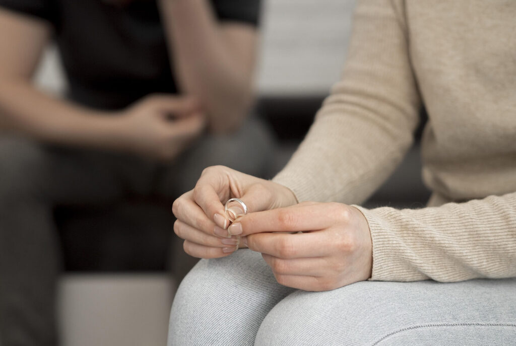 A woman holding her wedding ring in her hands. A marriage counselor in American Fork, UT is here to support your relationship. Contact us today to begin couples therapy.