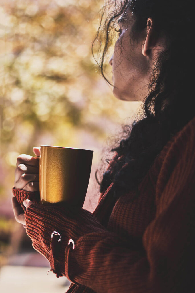A woman holding a gold coffee mug. If you're curious to learn more about religious trauma therapy in American Fork, UT then call today. Go through a faith transition with the support you deserve.