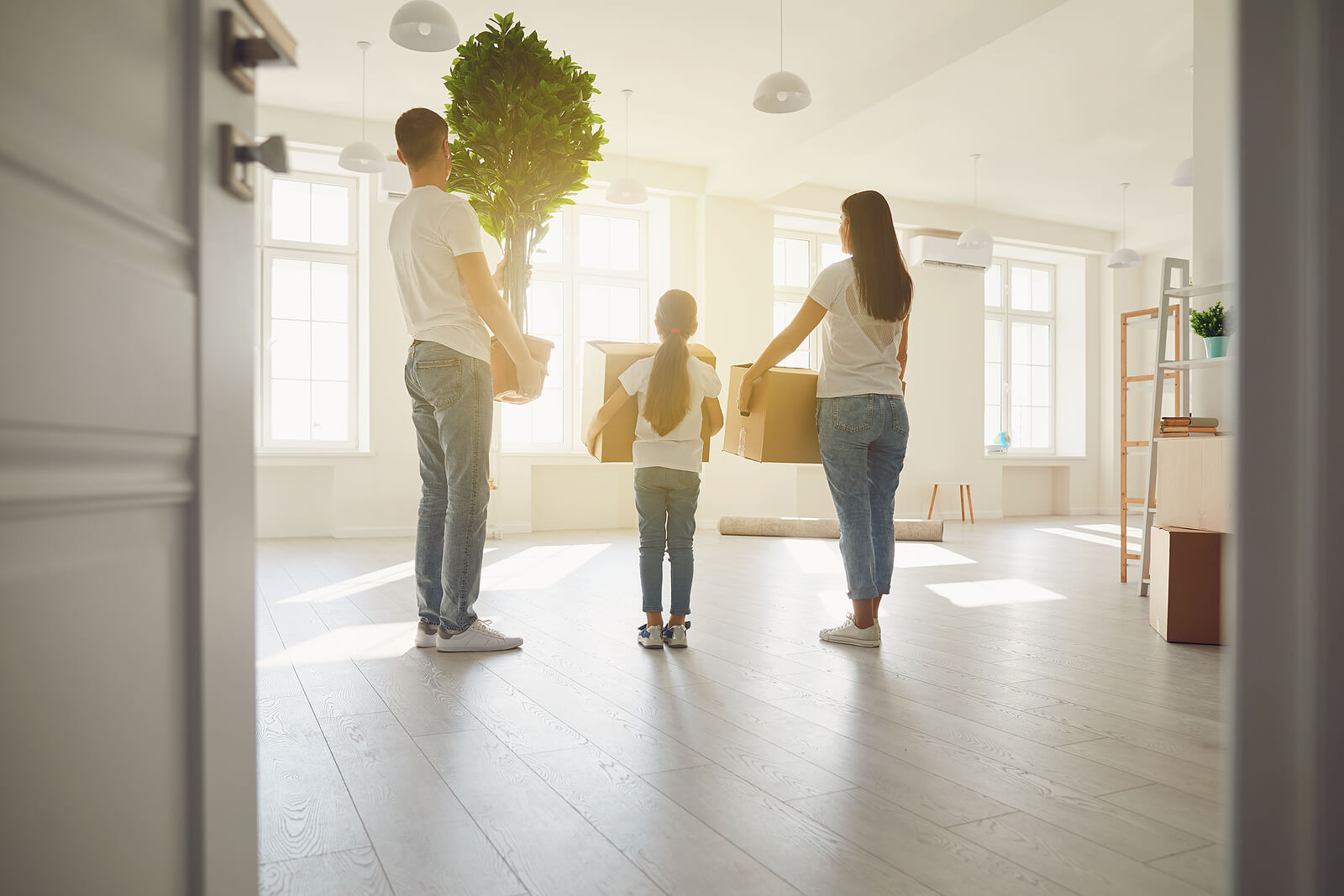 A family standing in their old home. Representing how life transitions might be easier with the help of a marriage counselor in American Fork, UT. Call today to get started with marriage counseling!