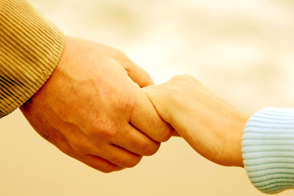 A couple holding hands. Representing how marriage counseling in American Fork, UT can help your marriage thrive. Call today for couples therapy!