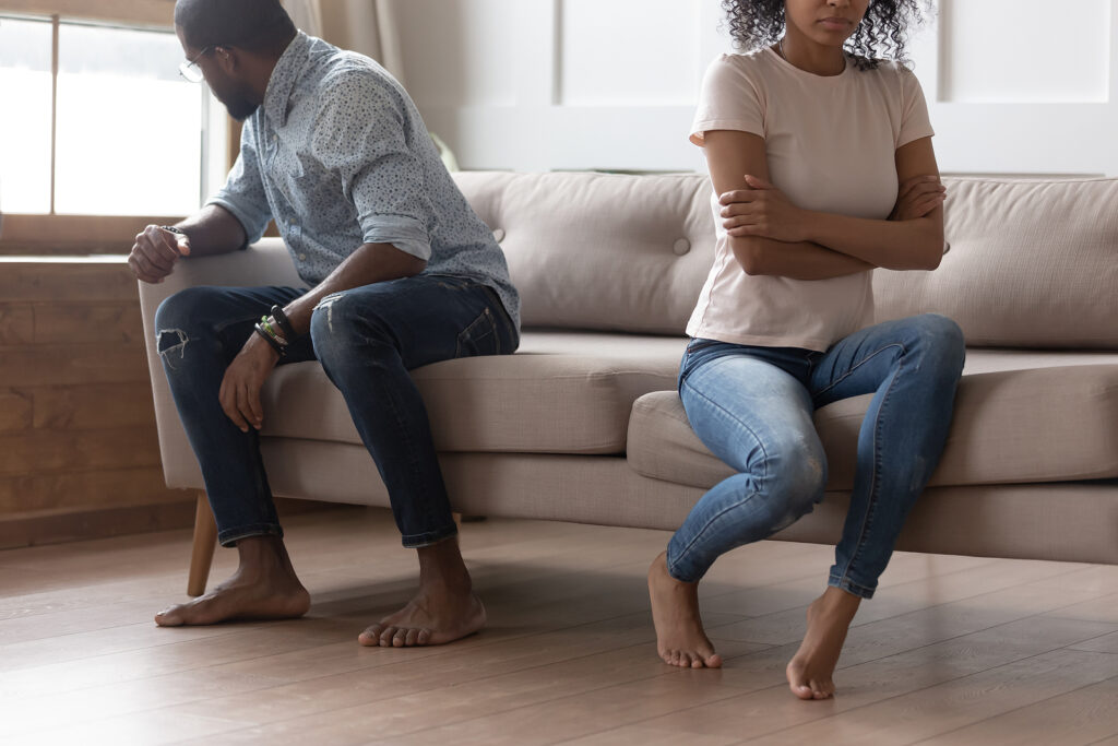 A couple sit facing away from one another on the same couch. This could represent the stress of relationships that couples counseling in American Fork, UT can offer support in overcoming insecure attachment. Learn more about couples communication therapy american fork, UT today.
