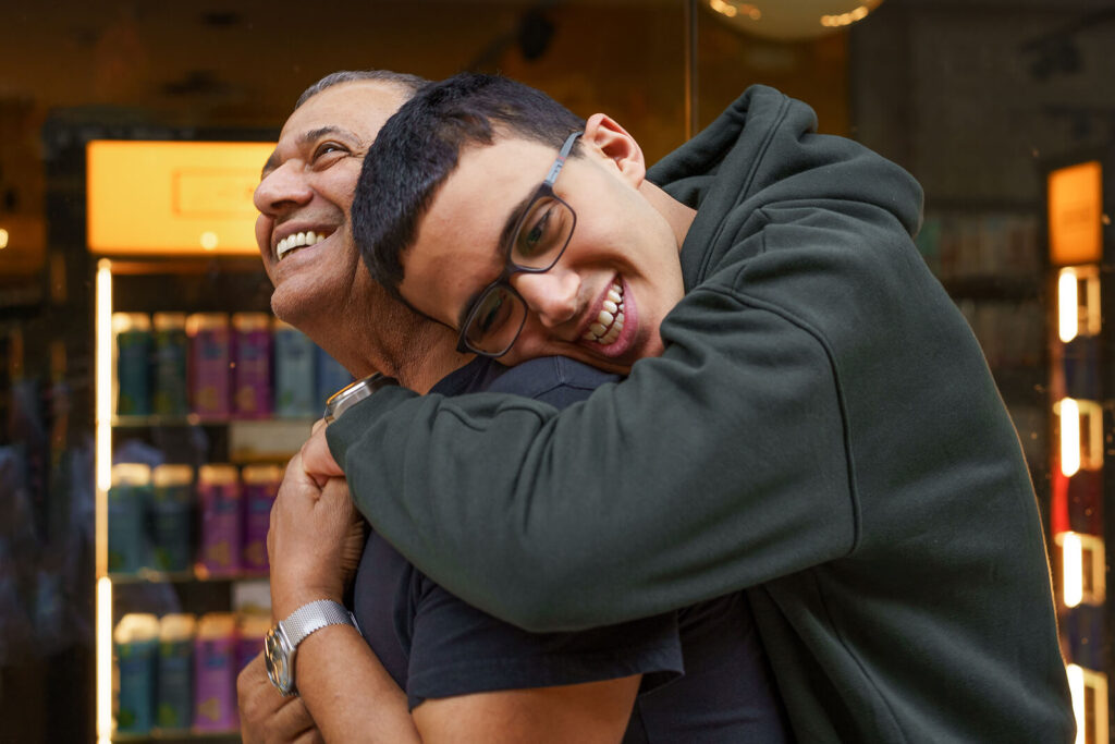 A teen hugs their dad while both smile. This could represent the bonds cultivated through therapy for teens in American Fork, UT. Learn more about teen OCD treatment American Fork, UT by searching for teenage counseling Utah today.
