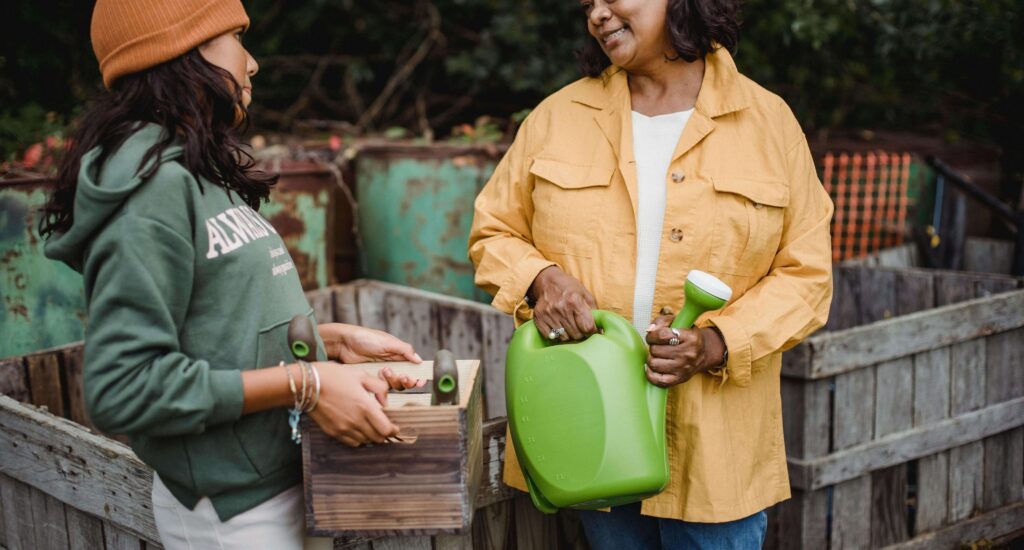 A woman in a yellow jacket holds a green watering can while talking to a young girl in a green hoodie and beanie, who carries a wooden gardening box. Learn how working with your teen can help cultivate deeper bonds. Search for therapy for teens in American Fork, UT and how a teen therapist near me and other services.
