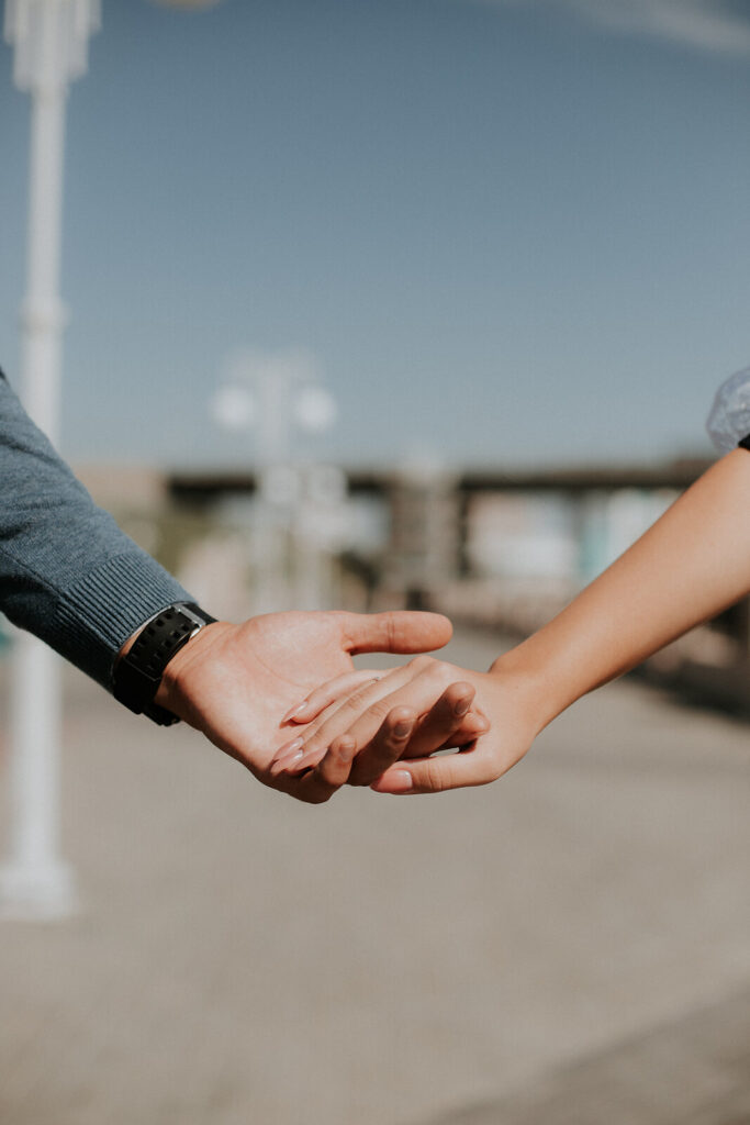  A close-up of a couple holding hands outdoors, with a soft background, conveying connection, and trust. Learn how a marriage counselor in American Fork, UT can offer support with building trust by searching for couples counseling in American Fork, UT. Search for marriage counseling American Fork, UT today. 
