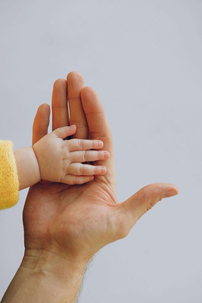child hand | couples therapy in american fork, UT | couples communication therapy | couples communication therapy american fork, ut | Close-up of a baby’s hand resting on an adult’s palm, symbolizing early relational patterns and attachment trauma in American Fork, UT that can be explored with a therapist in American Fork through couples counseling.